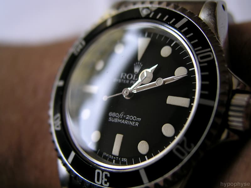 Rolex Submariner 5513 on the wrist: matte black no-date dial with the depth rating printed feet first (“660ft=200m”) above “Submariner”, two-line text, Mercedes hands and “Swiss – T<25” at six. · Photo: hypo.physe (Flickr) · CC BY-SA 2.0 · https://creativecommons.org/licenses/by-sa/2.0/ · Source: https://www.flickr.com/photos/hypophyse/4280478254/