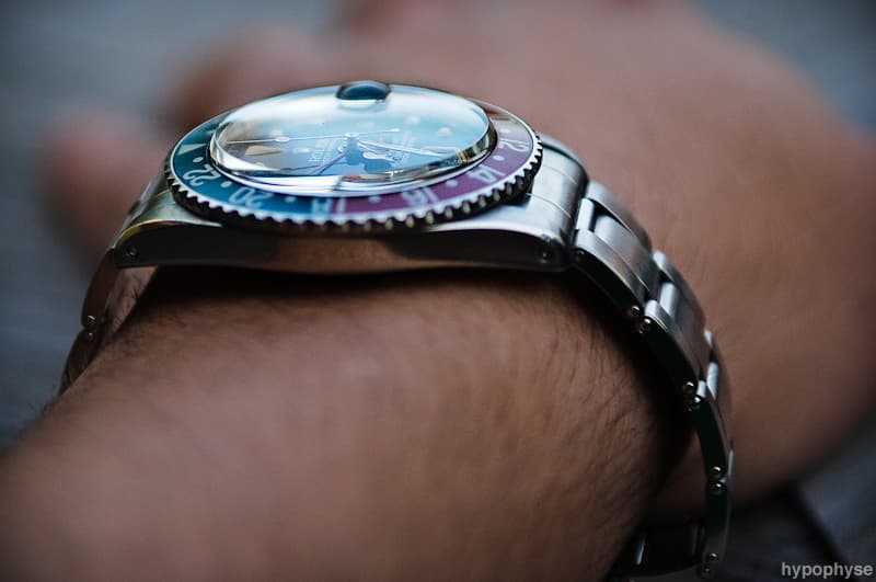Profile of an early pointed-crown-guard 1675 on the wrist, showing the domed acrylic crystal and the slim case. Case profile only. · Photo: hypo.physe (Flickr) · CC BY-SA 2.0 · https://creativecommons.org/licenses/by-sa/2.0/ · Source: https://www.flickr.com/photos/hypophyse/4778081009/