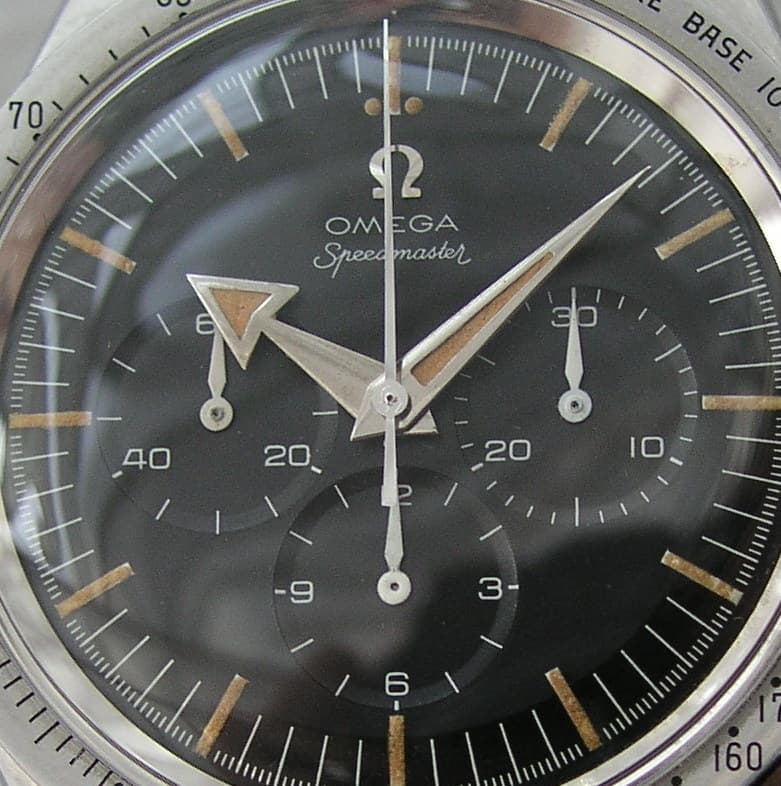 Dial close-up of the same Omega Speedmaster ref. CK2915: broad-arrow hands and steel tachymeter bezel. · Photo: Superspido (Wikimedia Commons user) · CC BY 2.5 · https://creativecommons.org/licenses/by/2.5 · Source: https://commons.wikimedia.org/wiki/File:Main_dial_OMEGA_Speedmaster_CK2915.JPG